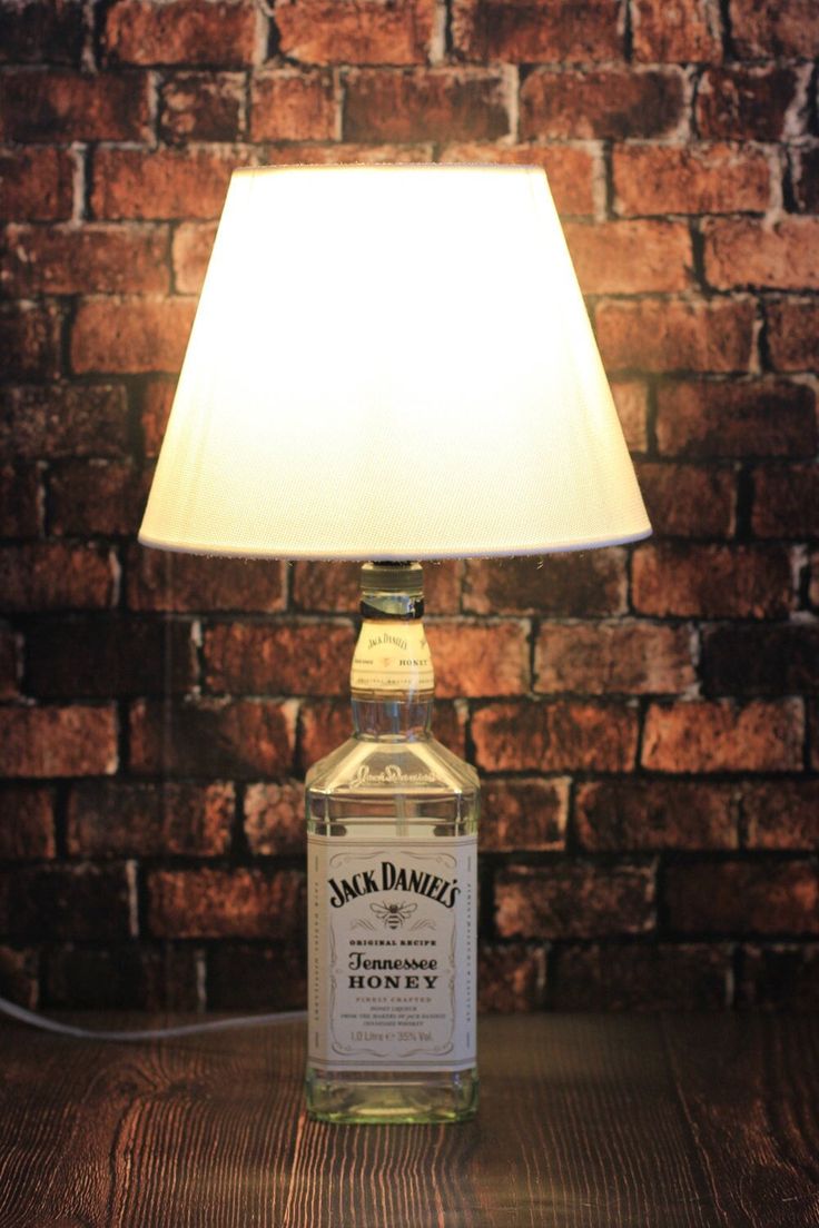 Jack Daniel's Tennessee Honey whiskey bottle repurposed as a lamp with a white shade against a brick wall.
Elegant ambient bottle lamp glowing in a modern living room setup, creating a warm and relaxing atmosphere.
Modern rechargeable bottle light for stylish home decoration, romantic dinners, cafes, bars, and gifting purposes.