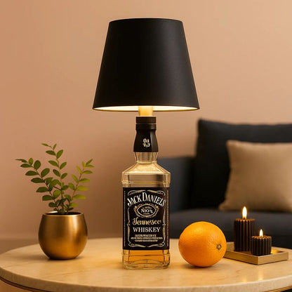 Jack Daniel's whiskey bottle repurposed as a lamp with a black shade on a table. Luxury bottle lamp with USB-C charging and adjustable brightness, designed for premium home and office decor.